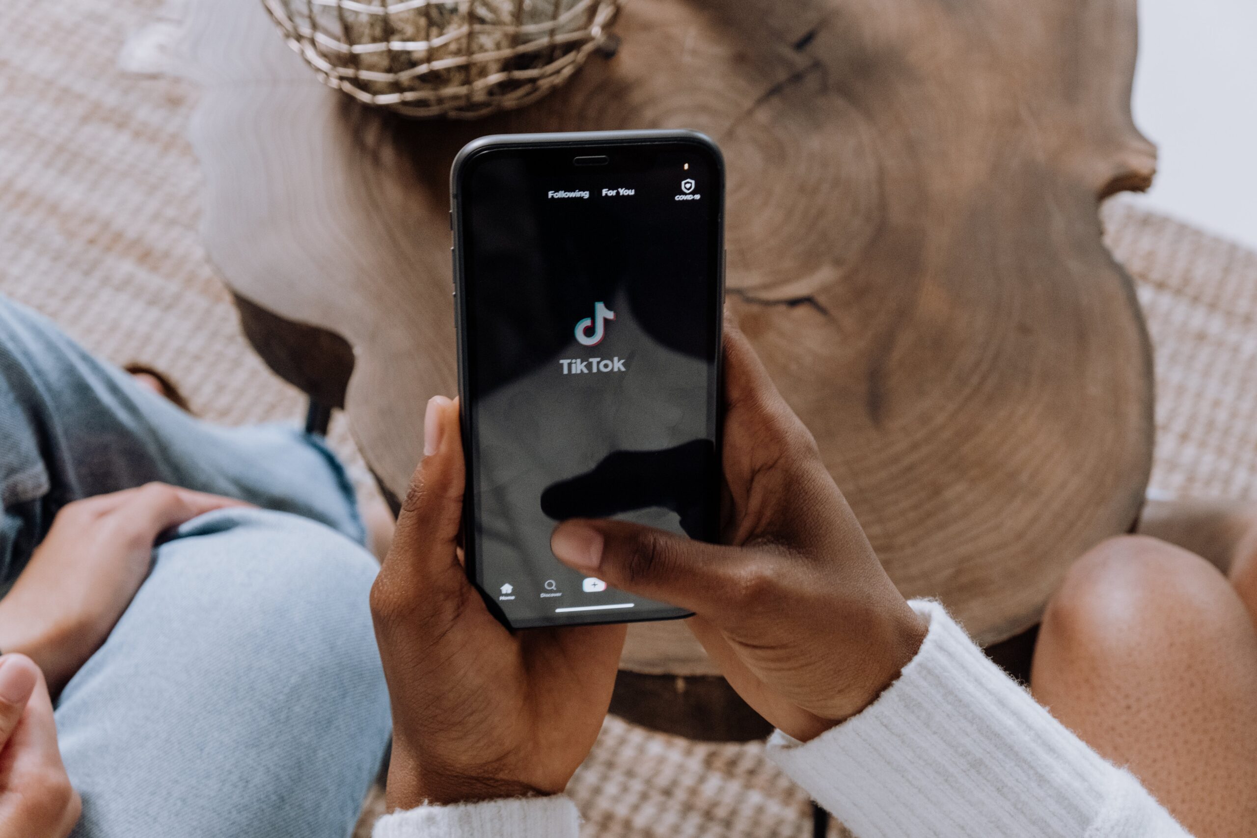 Person holding a smartphone with the TikTok app open, symbolizing the rise of video platforms in current social media trends