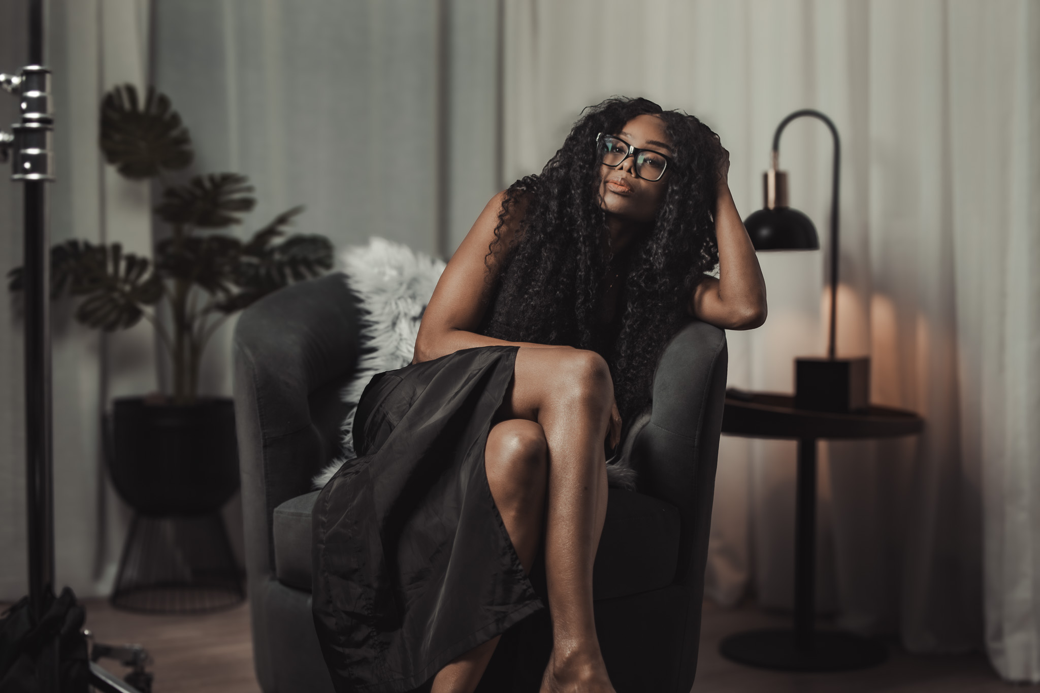 Bess Obarotimi seated in a dimly lit studio, reflecting during the Spiritual Authenticity I AM Success Mini-Series.