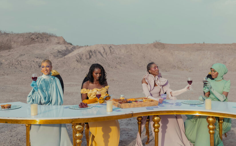 Women sharing drinks outdoors at a long table, dressed in elegant colours, symbolising making friends in your 40s and enjoying meaningful connection.
