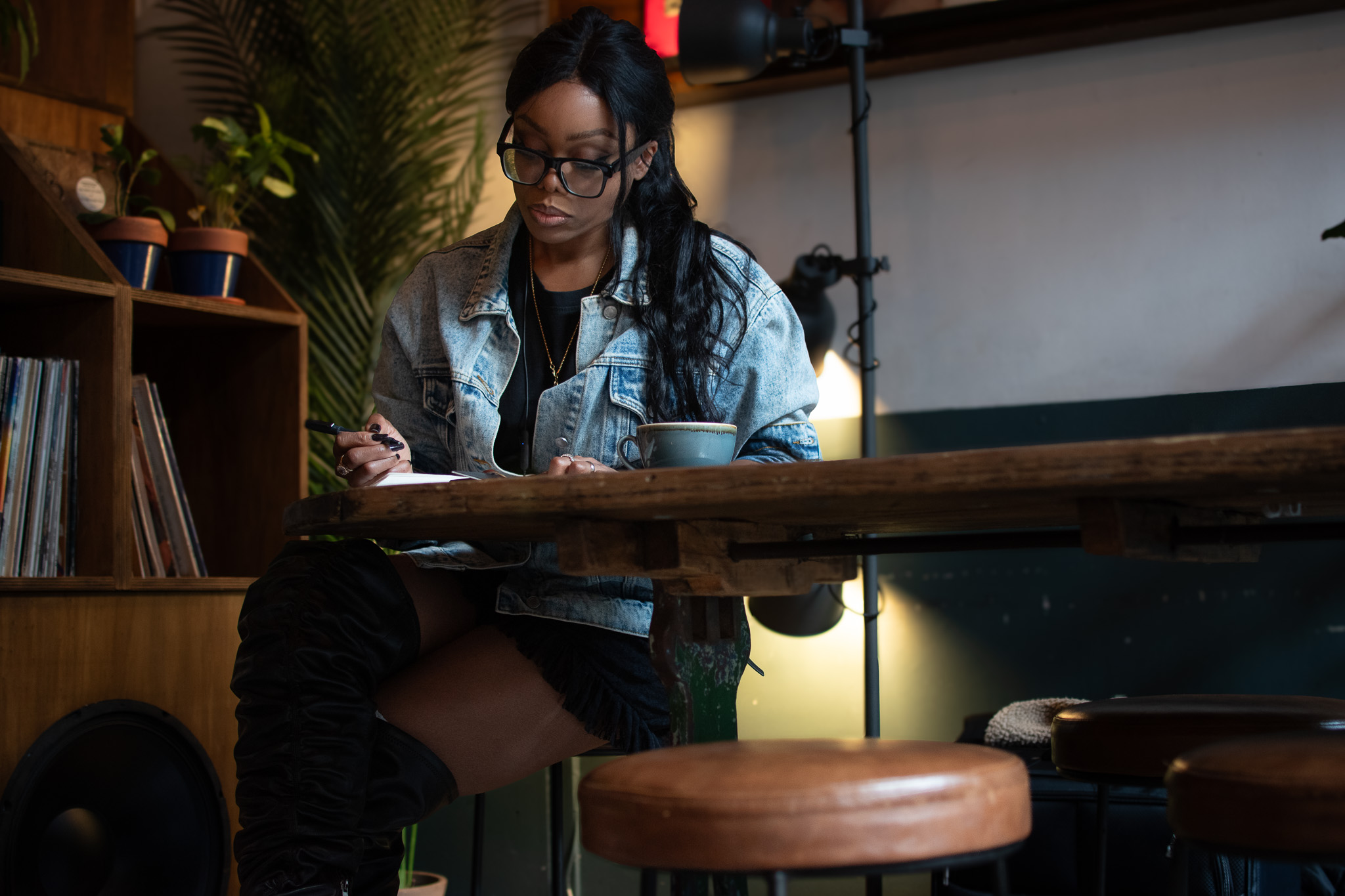 Bess Obarotimi writing notes in a café while developing ideas on the execution gap and strategy execution