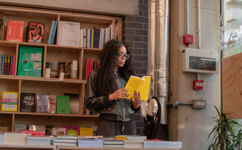 Bess Obarotimi reading in a bookshop while reflecting on decision authority and organisational governance