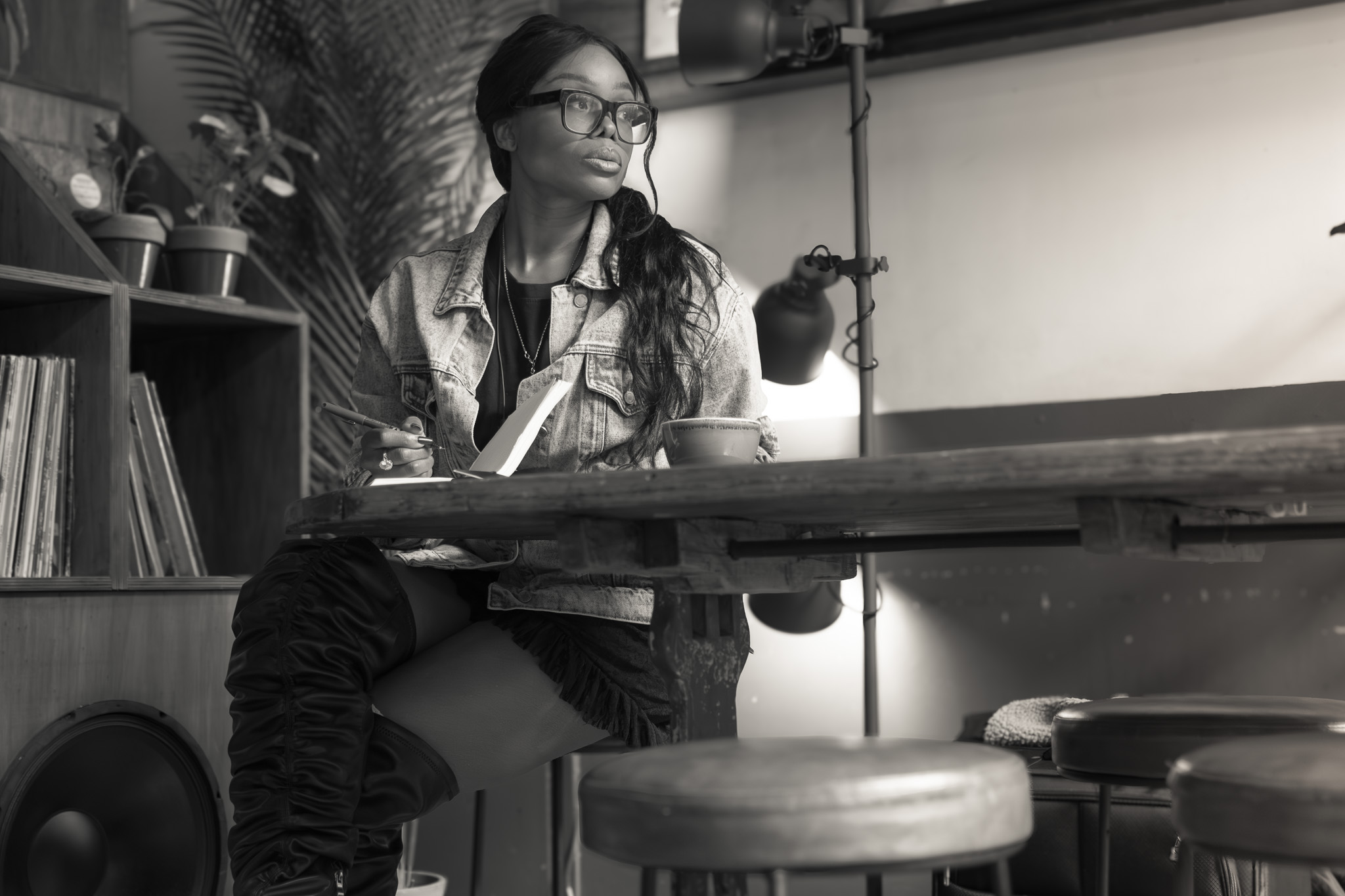 Woman seated at a café table with a notebook, considering internal authority in AI decision-making.